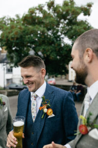 groom smiling with groomsmen Rustic farm family wedding in devon