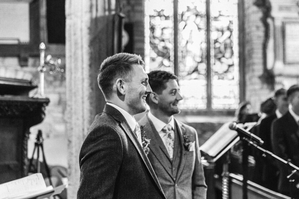 Groom first look at sees bride for the first time in small rustic wedding ceremony in church
