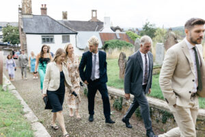 Wedding guests arriving at Devon church Rustic farm family wedding in devon