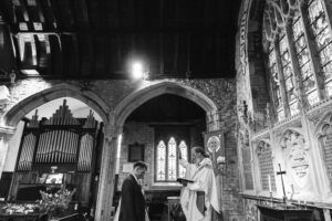 Priest blesses newly married couple in church wedding during ceremony in Devon