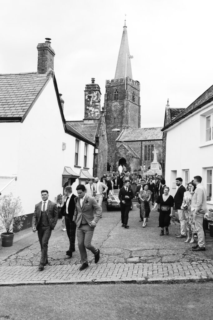 guests leave wedding cermony in black and white photo
