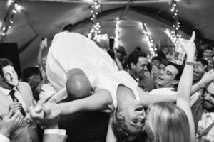 Bride crowed surfs during wedding captured with photography and videography black and white