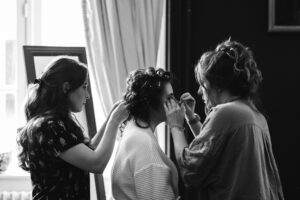Bridemaids helping bride get ready in black and white photo