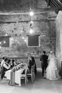 Bride and groom enter wedding reception black and white photo