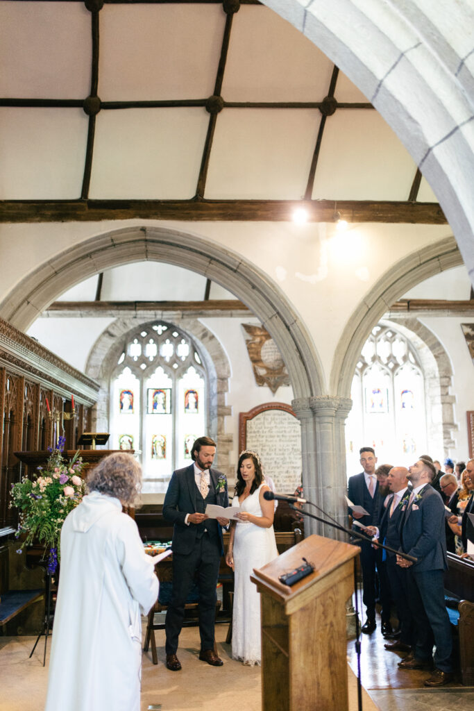 Groom and bride sing a hymn during their wedding ceremony 