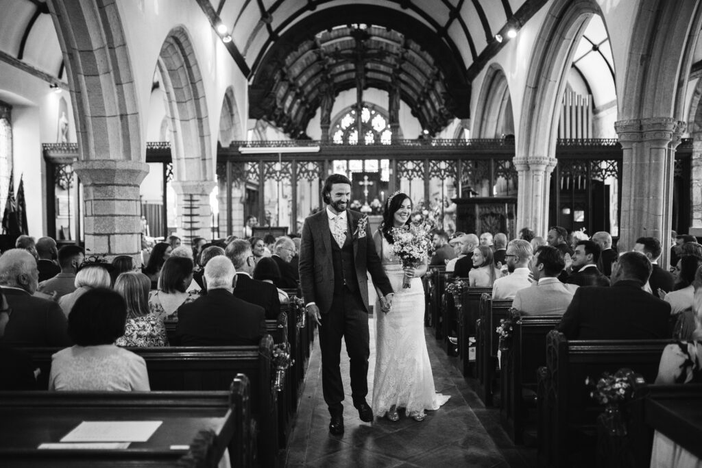 Bride and groom leave the church in Cornwall after getting married