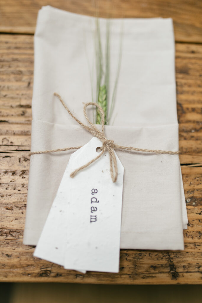 Close up of details on the table on a wedding day, linen napkin tied with string with corn 