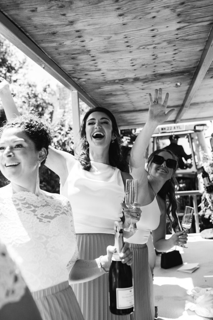 Guests wave hello to bride and groom as they arrive for their wedding reception in Cornwall 