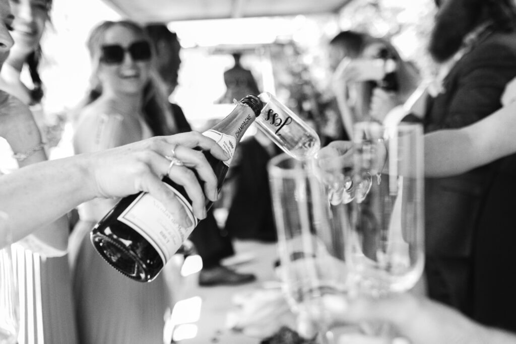 Guests pour champagne in the back of a car