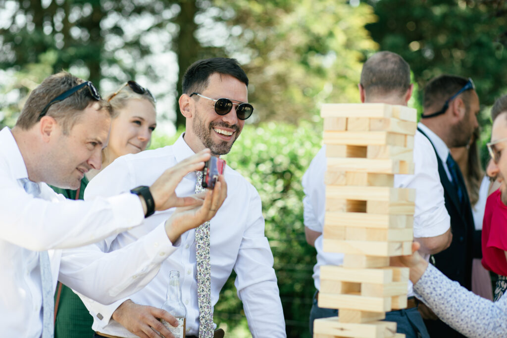 Wedding guest smiles and plays jenga during the reception