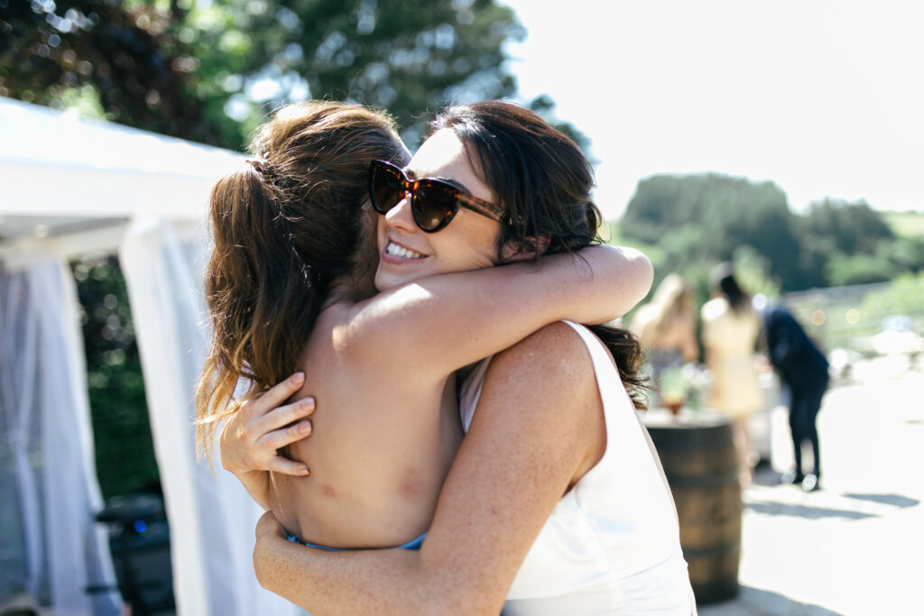 Wedding guests embrace during candid moment