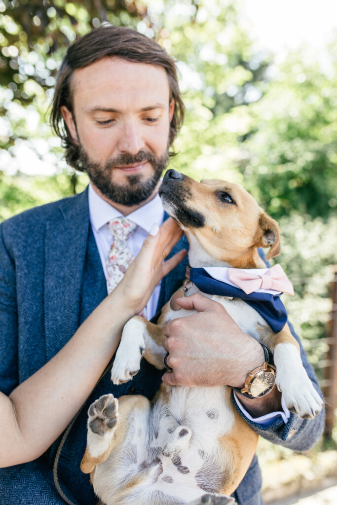 Groom holds his dog during the reception