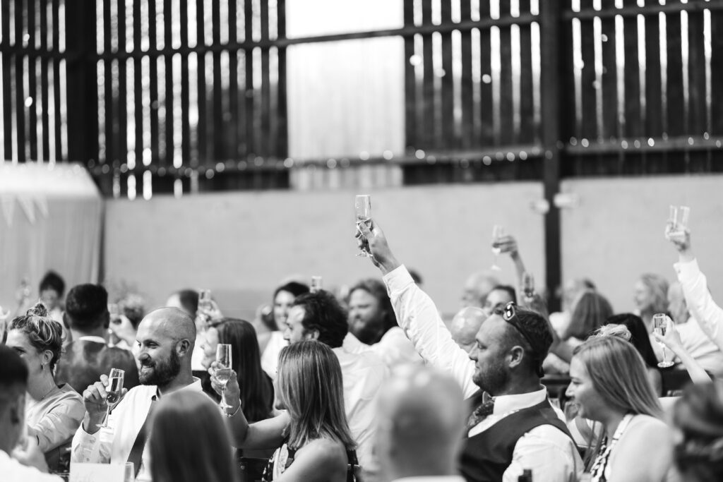 Guests cheers during the speeches at the wedding reception