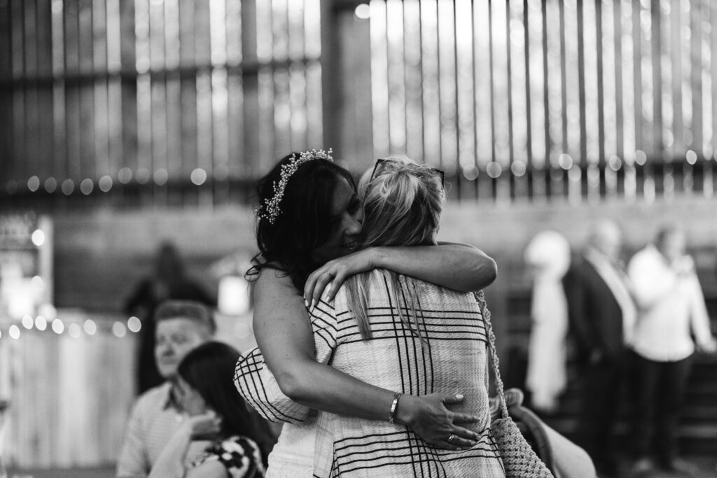 Candid moment of bride hugging a wedding guest 