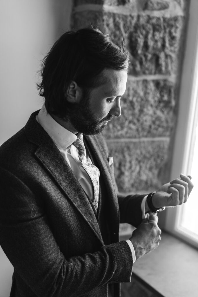 Groom puts on watch and gets ready for his wedding day 