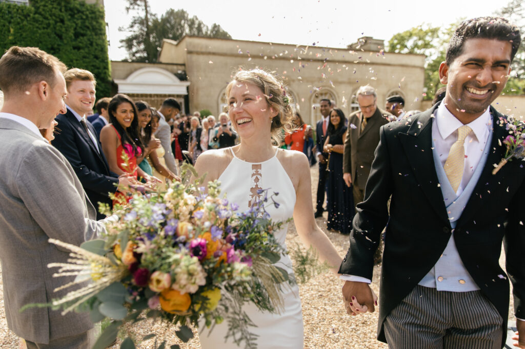 Bride and groom walk out after confetti is thrown 