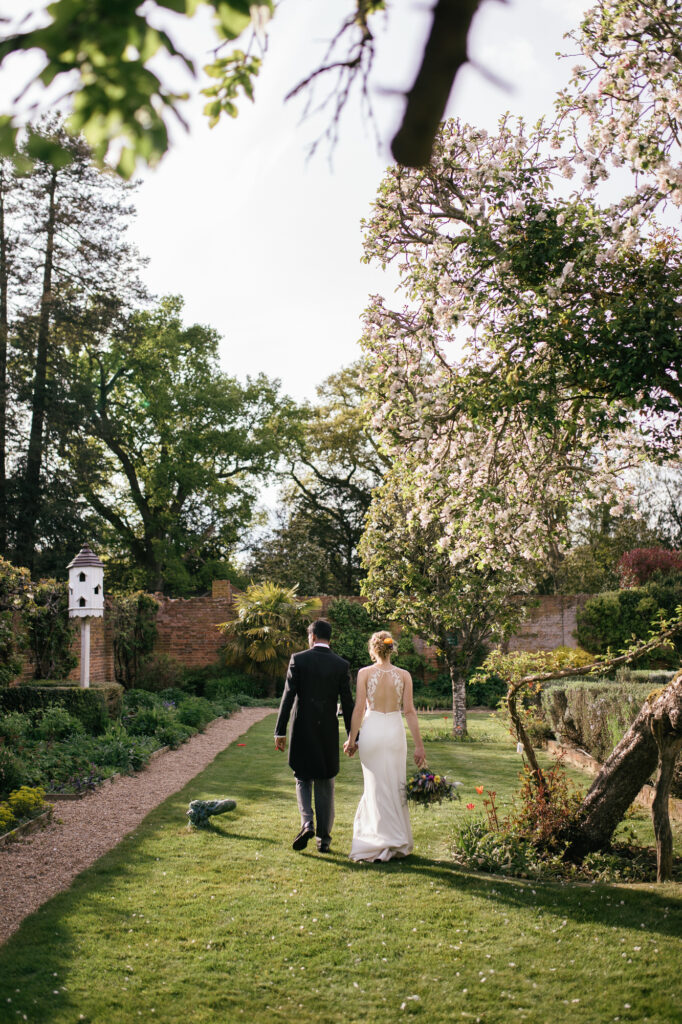 Bride and groom take a walk through their wedding venue gardens 