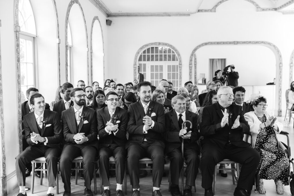 Wedding guests clap after bride and groom get married 