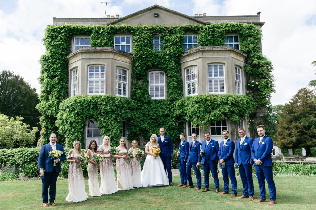 Bridal party pose for photograph outside of Northbrook park wedding venue in Hampshire 