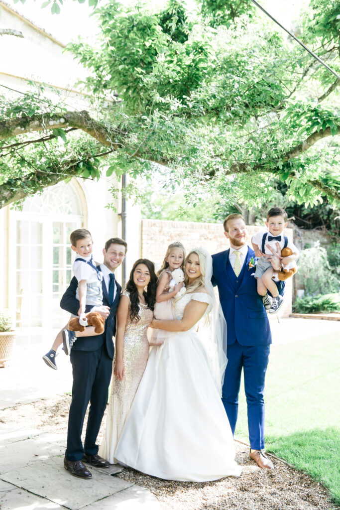 Bride and groom pose with kids for wedding photograph