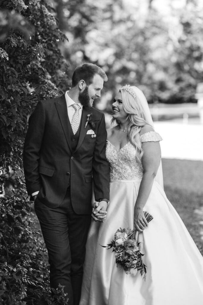 Bride and groom take a walk along the gardens during their wedding reception