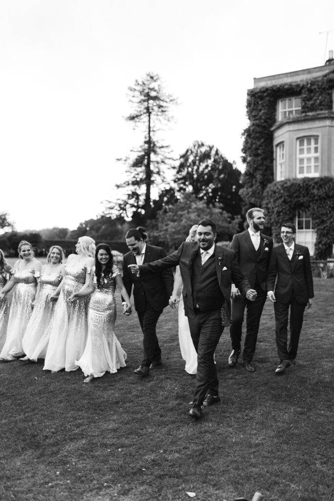 Bridal party walk along the lawn during wedding videography