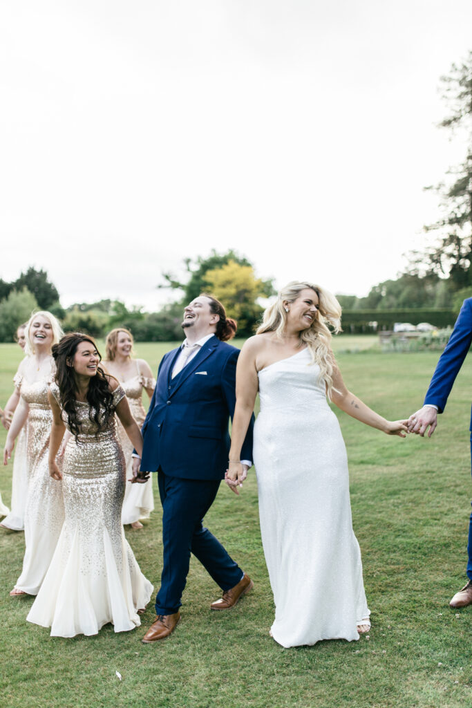 Bridal party laugh and walk during wedding day