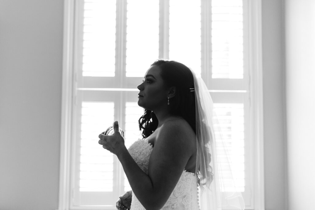 Bride is applying perfume whilst getting ready in the morning of the wedding 