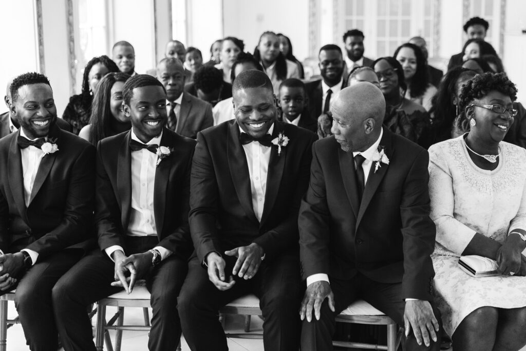 Wedding guests laugh during ceremony 